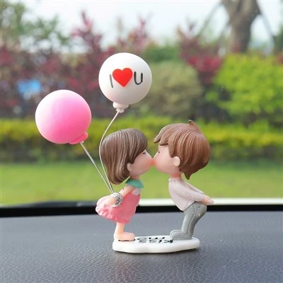 Couple se tenant la main, ballon, figurine de voiture